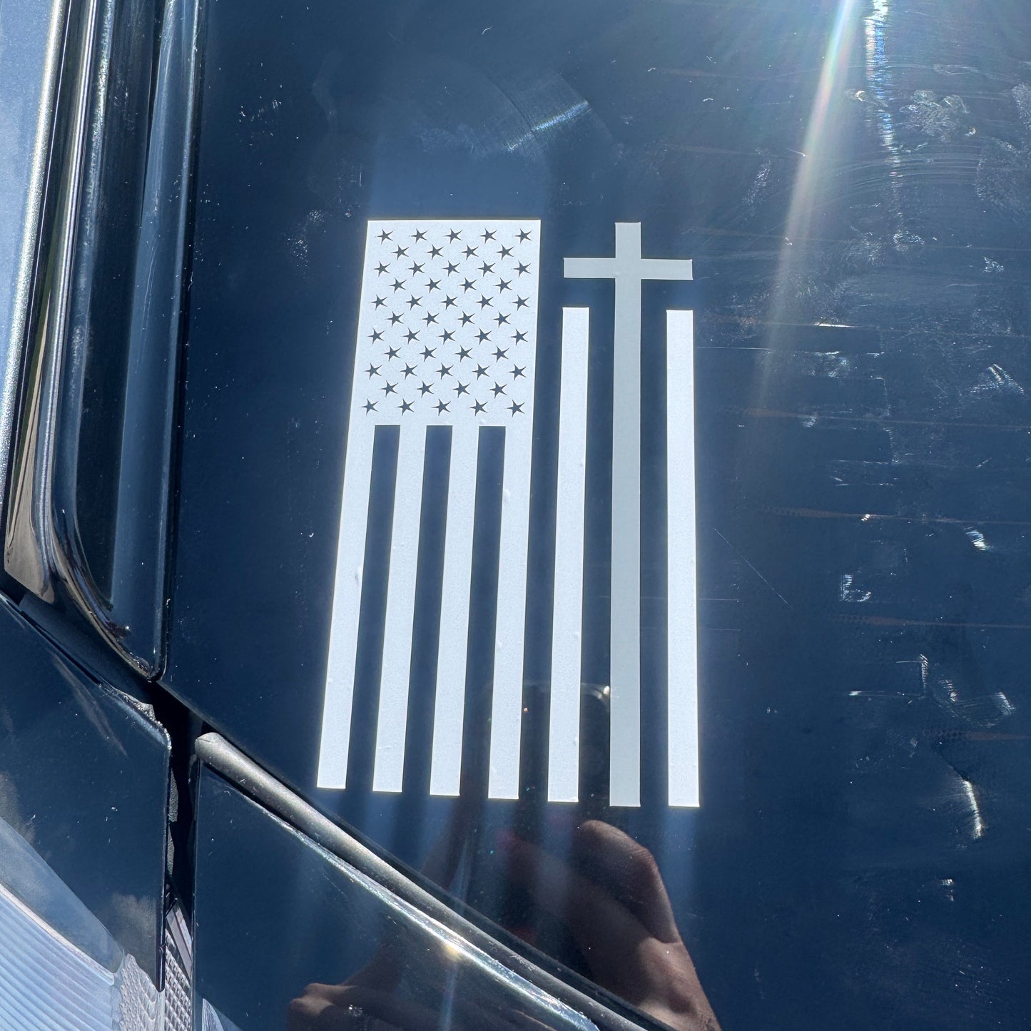 White flag decal with cross on a black car window