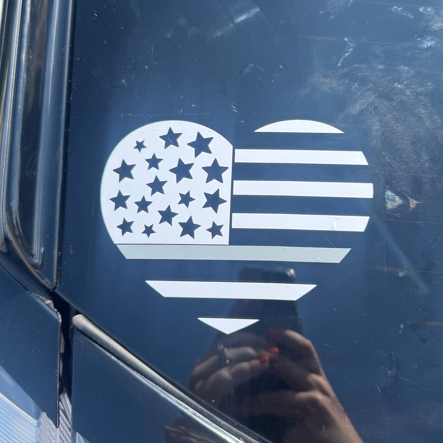 White decal of a hand with stars and stripes on a car window
