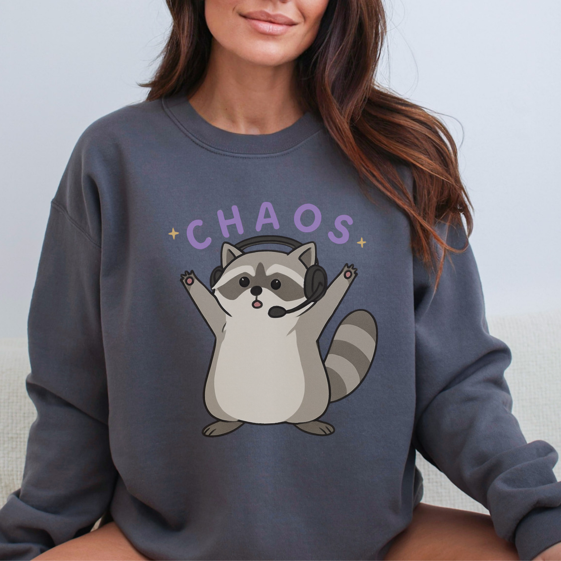 Person wearing a dark gray sweatshirt with a raccoon graphic and 'CHAOS' text.