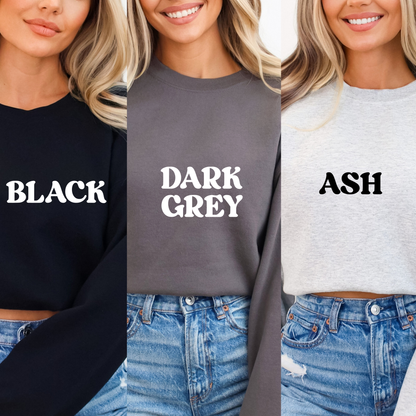 Three women wearing black, dark grey, and ash sweatshirts with color labels.