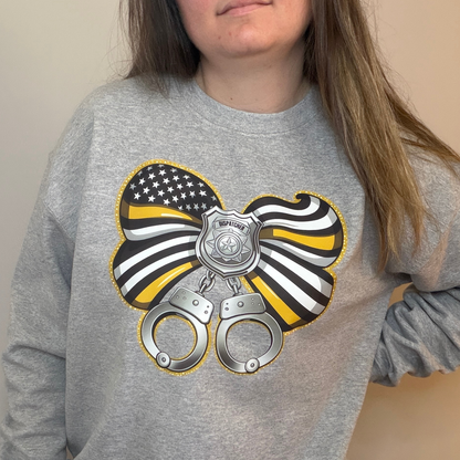 Gray sweatshirt with a graphic design of handcuffs, an American flag, and a police badge on a plain background.