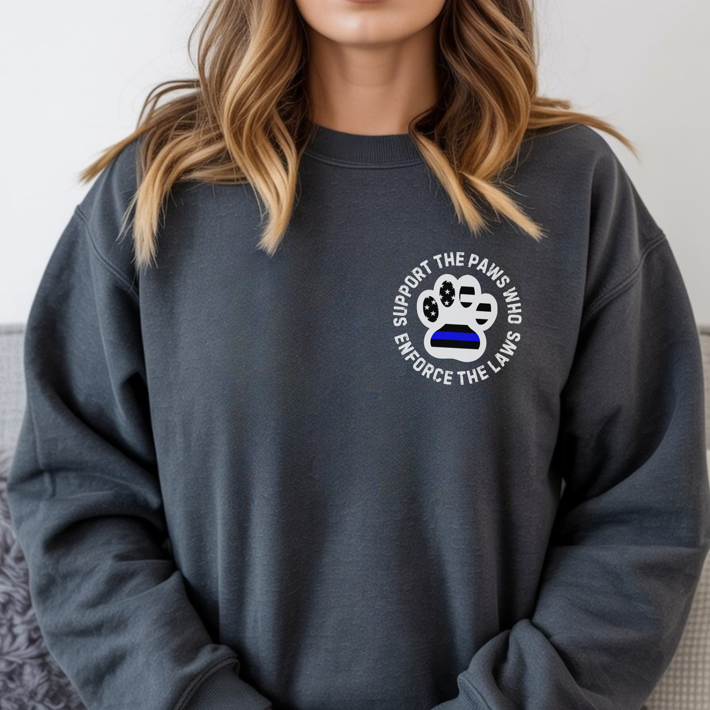 Person wearing a dark gray sweatshirt with a paw print design and text.