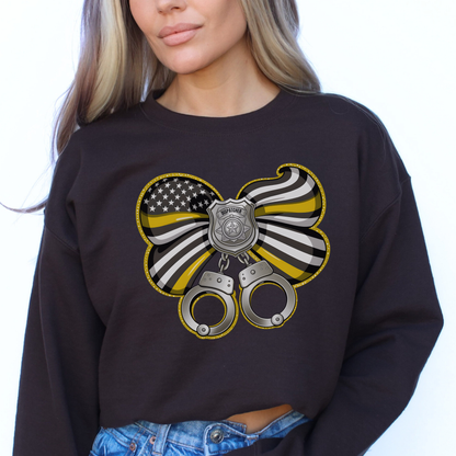 Black sweatshirt with a butterfly design featuring an American flag, police badge, and handcuffs worn by a person.