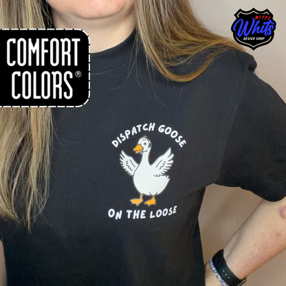 Person wearing a black Comfort Colors t-shirt with a 'Dispatch Goose on the Loose" graphic.