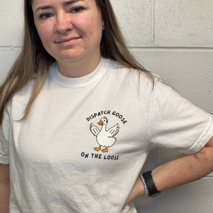 Person wearing a white Comfort Colors t-shirt with a 'Dispatch Goose on the Loose" graphic.
