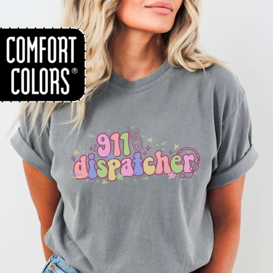Person wearing a gray t-shirt with '911 dispatcher' text in colorful letters, featuring Comfort Colors logo.